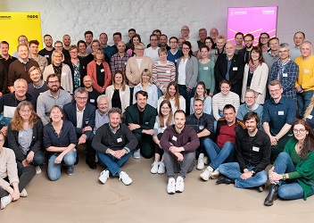 Das Bild zeigt eine Gruppe von mehr als 50 Menschen, die sich in einem Raum zu einem Gruppenbild aufgestellt haben (verweist auf: „GEMEINSAM GEGEN DOPING“ – Netzwerk­veranstaltung 2023: Kommunikation im Fokus)