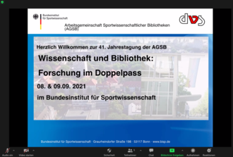 Das Foto zeigt den Begrüßungsbildschirm der digitalen Jahrestagung der Arbeitsgemeinschaft Sportwissenschaftlicher Bibliotheken. Darauf zu sehen ist der Titel der Veranstaltung "Wissenschaft und Bibliothek: Forschung im Doppelpass" sowie das Datum.